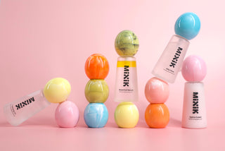 MIXIK bottles arranged on pink background with colorful MIXIK egg shaped caps